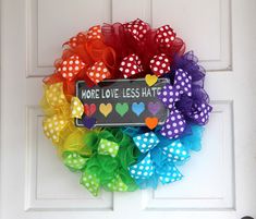 a colorful wreath with hearts and a sign that says more love less hate