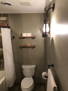 a bathroom with a toilet and shelves above it