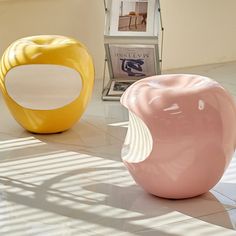 two colorful vases sitting on top of a white tiled floor next to each other