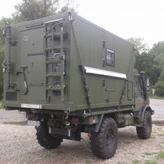 an army truck is parked on the gravel