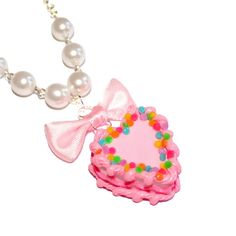 This adorable miniature birthday cake necklace is a special way to celebrate your birthday or make everyday your birthday! It was inspired by all those fabulous kitschy and girly pink birthday cakes we had growing up.This cake is adorned with classic birthday cake details like pink piped frosting, frilly bright pink icing along the middle, and topped with bright rainbow confetti sprinkles. The cake hangs below a lovely pink bow from a high quality glass pearl beaded chain and silver plated chain Pink Kawaii Jewelry For Valentine's Day, Kawaii Pink Jewelry For Valentine's Day, Pink Charm Necklace For Gifts, Pink Heart-shaped Charm Necklace For Party, Pink Heart Charm Necklace For Party, Personalized Pink Charm Necklaces For Birthday Gift, Charming Pink Necklace For Gift, Playful Pink Party Necklaces, Pink Playful Party Necklaces