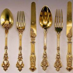 four different types of gold colored forks and spoons with ornate designs on the sides