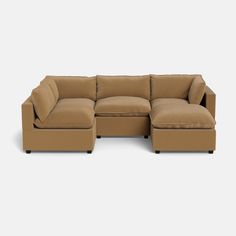 a tan sectional couch sitting on top of a white floor