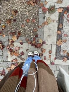 a person standing on top of a tiled floor next to leaves