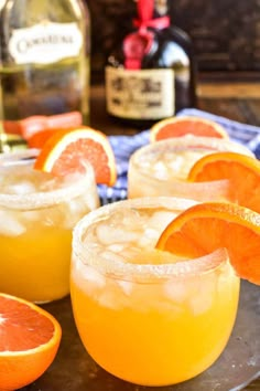 two glasses filled with orange juice and garnished with an orange slice on the rim