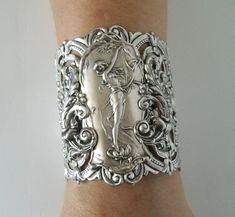 "Art nouveau Bracelet This beautiful silver plated cuff bracelet has a silver plated art nouveau maiden, silver plated chain and lobster clasp. 2.75\" at the widest part. 7\" long adjustable to 9\" long." Vintage Silver Jewelry With Historical Design, Victorian Hallmarked Cuff Bracelet As A Gift, Victorian Engraved Cuff Bracelet For Gift, Art Nouveau Jewelry With Historical Design For Gift, Art Nouveau Jewelry With Historical Design As Gift, Silver Jewelry With Historical Design As Gift, Silver Jewelry With Historical Design For Gift, Adjustable Silver Art Deco Bracelets, Handmade Victorian Cuff Bracelet For Wedding