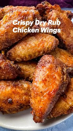 fried chicken wings are piled on a white plate