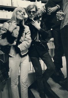 black and white photograph of three people standing in front of bookshelves with glasses on