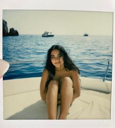 a naked woman sitting on the back of a boat