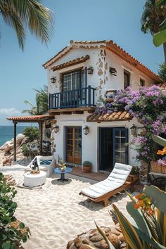 a white house with blue shutters on the front and balcony overlooking the ocean in mexico