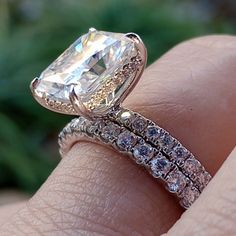 a close up of a person's hand with a diamond ring on their finger