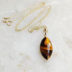 "You can choose your own gem in my store. Let me know if you would like to see options Gemstone: Brown YellowTiger Eye Gold Purity : Guaranteed 14kt pure GOLD Gem weight 9.60 carats Gem shape: Marquis Cabachon shape Gold weight: 0.56 grame Total weight: 2.48 grame The Gemstone in this pendant is ethically sourced and is exploitation free. Brown Yellow Tiger Eye is a beautiful Gemstone of patterns like no other Gemstone. Please note that the pendant is made with absolutely pure 14kt Gold. Pendant 14k Gold Gemstones With Bezel Setting For Gift, 14k Gold Cabochon Jewelry As Gift, Yellow Gold Gemstone Pendant Necklace, Yellow Gold Cabochon Teardrop Pendant Necklace, Yellow Gold Pendant Necklace With Gemstone, Hallmarked Yellow Gold Gemstones For Gift, Marquise Yellow Gold Jewelry Gift, Marquise Yellow Gold Jewelry As A Gift, Marquise Yellow Gold Jewelry For Gift