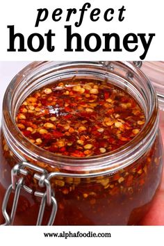 a jar filled with hot honey sitting on top of a table