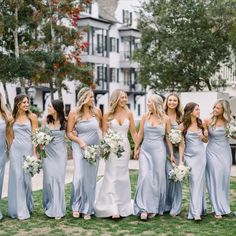 a group of bridesmaids standing in the grass