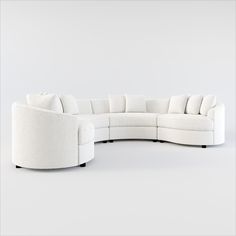 a large white sectional couch sitting on top of a white floor next to a chair