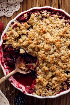 a berry crumbled dessert in a bowl with a spoon