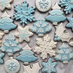 blue and white cookies decorated with snowflakes, christmas trees, and other decorations