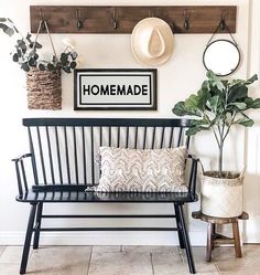 a black bench sitting next to a potted plant on top of a wooden shelf