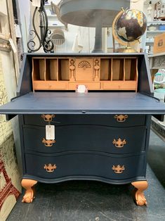 an antique desk with drawers and a clock on top