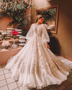 a woman in a wedding dress standing next to a mirror