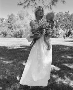 a woman in a white dress holding a bouquet of flowers