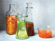 three glass vases filled with different colored liquid