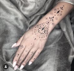 a woman's hand with tattoos on it