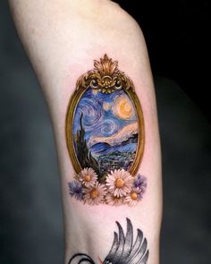 a woman's arm with a painting on it and flowers in front of her