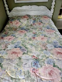 a bed with a flowered bedspread on top of it