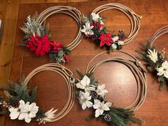 four christmas wreaths are arranged on a table