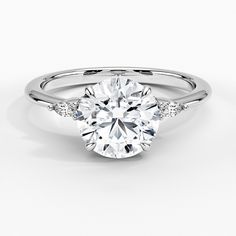 a white gold engagement ring with diamonds on the shoulders and an oval cut diamond in the center