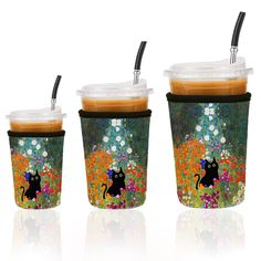 three cups with lids and straws decorated with black cats on them, one is filled with coffee