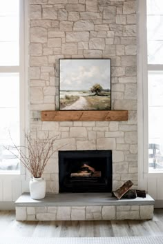 a fireplace with a painting above it and a vase on the mantle next to it