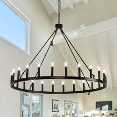 a large chandelier hanging from the ceiling in a living room with white walls