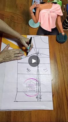 a woman is drawing on paper with scissors