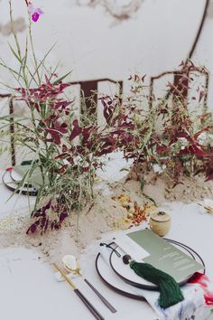 the table is set with place settings, flowers and other things to be used for decoration