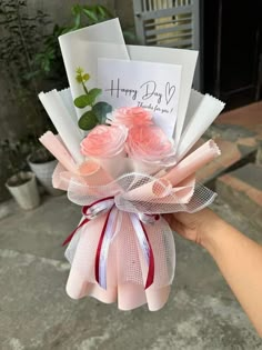 someone is holding a bouquet of flowers in front of a card that says happy day