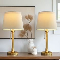 two lamps sitting on top of a wooden table