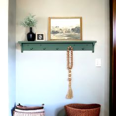 a shelf with beads and a painting on it next to a wicker basket in the corner