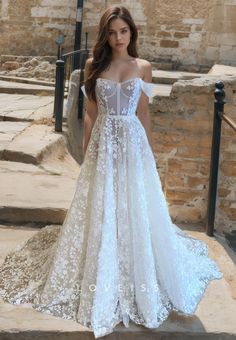 a woman in a white wedding dress standing on steps