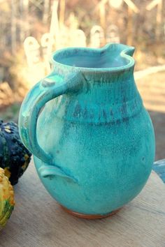 a blue pitcher sitting on top of a wooden table