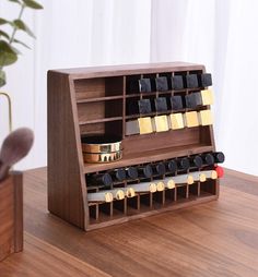 a wooden display case with several different types of items in it on a table next to a potted plant