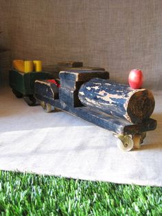 an old wooden toy train with apples on it