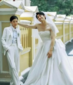 a man and woman in wedding attire standing next to each other