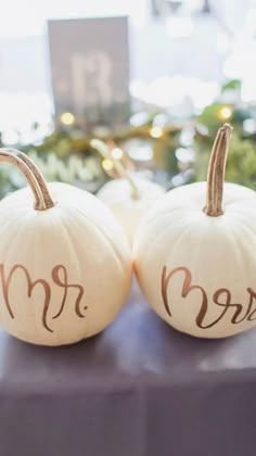 two white pumpkins with the word mr and mrs painted on them sitting next to each other