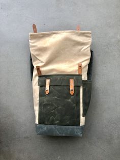 "Medium size backpack made from heavy weight waxed canvas in the color natural with an outside pocket and bottle pocket made in waxed canvas color olive green. Bottom and shoulder straps are made in grey waxed canvas I made it into an everyday backpack/rucksack, with waxed canvas padded straps. Roll to close top, and outside pocket with protective flap. This backpack as a bottle pocket on one side The bag closes with roll to close system and snaps with a vegetable tanned leather strap. This medi Waxed Canvas Leather Backpack, Hipster Backpack, Waxed Canvas Backpack, Commuter Backpack, Everyday Backpack, Green Bottom, Roll Top, Small Pouches, Canvas Backpack