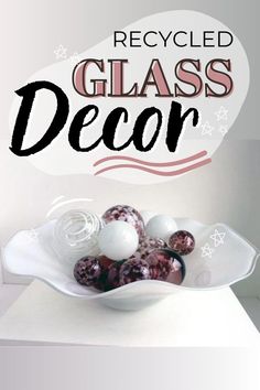 a glass bowl filled with marbles on top of a white table next to a sign that reads recycled glass decor