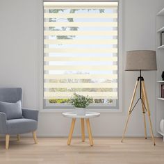 a living room with two chairs and a table in front of a window that has blinds on it