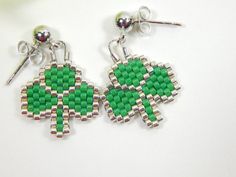 the earrings are made out of beads and have green shamrocks on them, as well as silver earwires