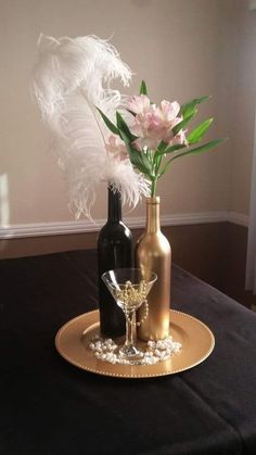 two vases with flowers in them sitting on a gold plate next to each other